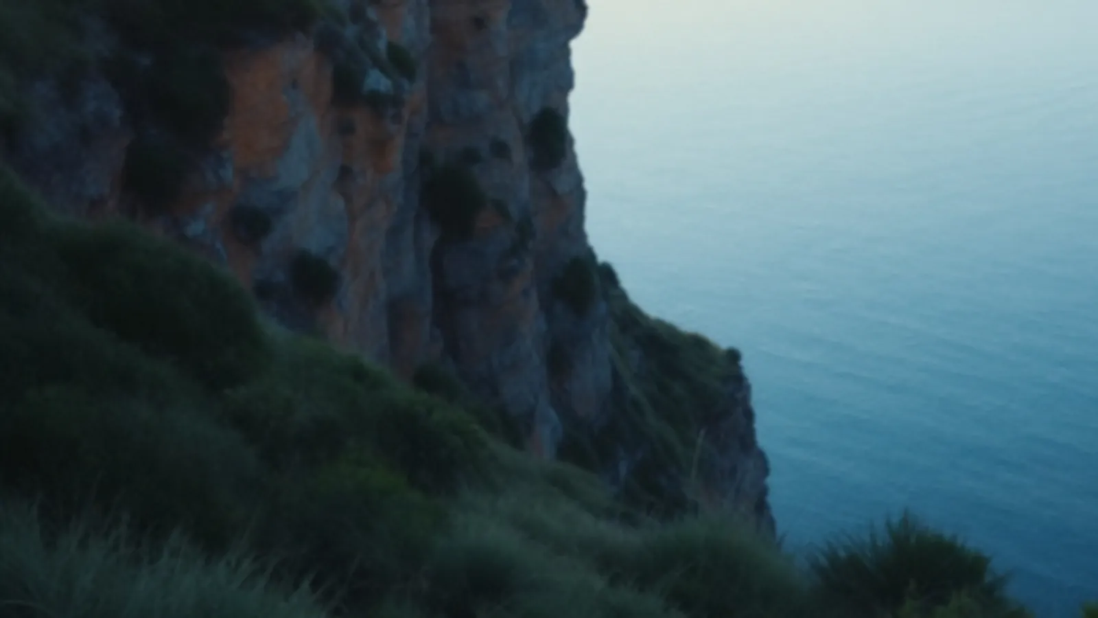 A tall grassy bluff above a wide calm blue sea at sunrise, the FinanceBluff view of bad credit personal loans, $100 – $5,000